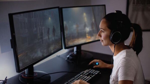 Rapariga a jogar usando dois ecrãs num computador com processador Intel i9