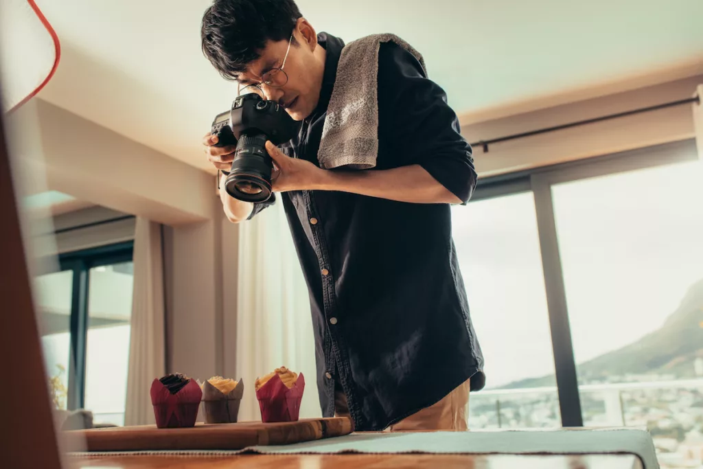 Fotógrafo a tirar foto a cupcakes com câmara DSLR