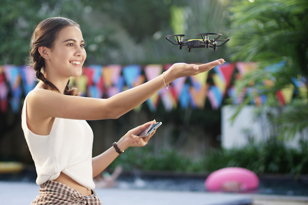 Rapariga a sorrir enquanto manobra um pequeno drone DJI