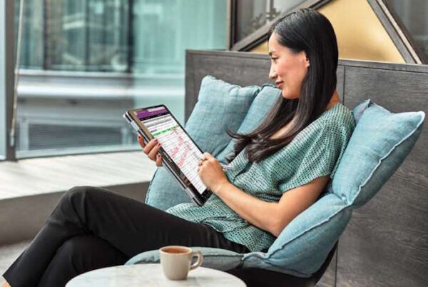 Senhora sentada num sofá a trabalhar num tablet com a Windows Ink