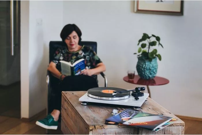 Rapaz a ler com um gira-discos em cima da mesa