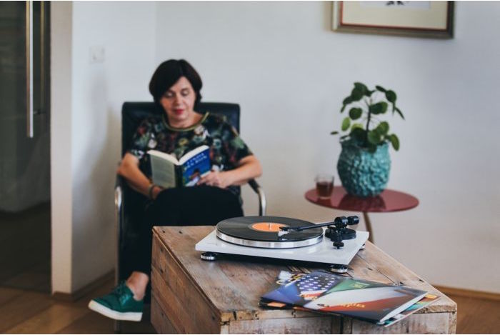 Rapaz a ler com um gira-discos em cima da mesa